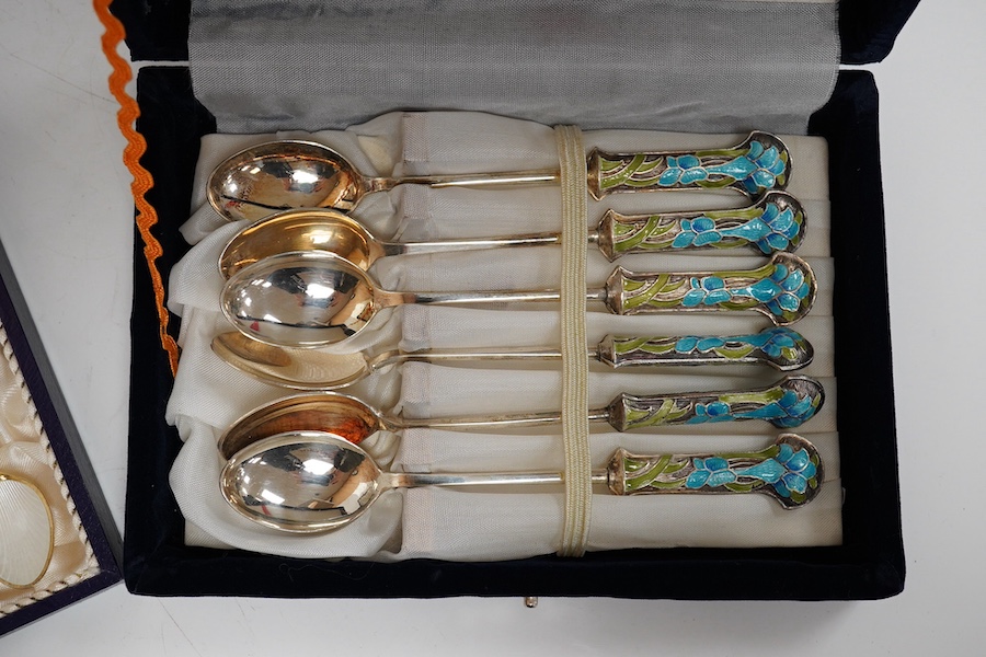 A mid 20th century cased set of six Danish gilt sterling and polychrome enamel coffee spoons, by Egon Lauridson, 94mm, together with one other set of six white metal and enamelled teaspoons, stamped 'silver'. Condition -